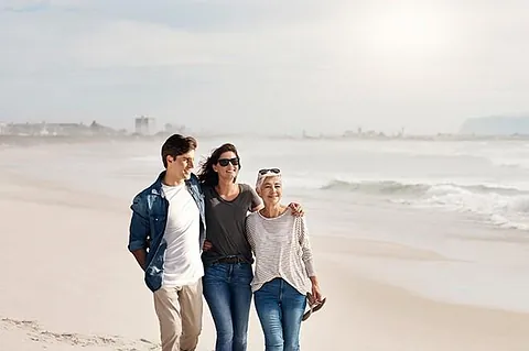 Familia de tres paseando por la playa